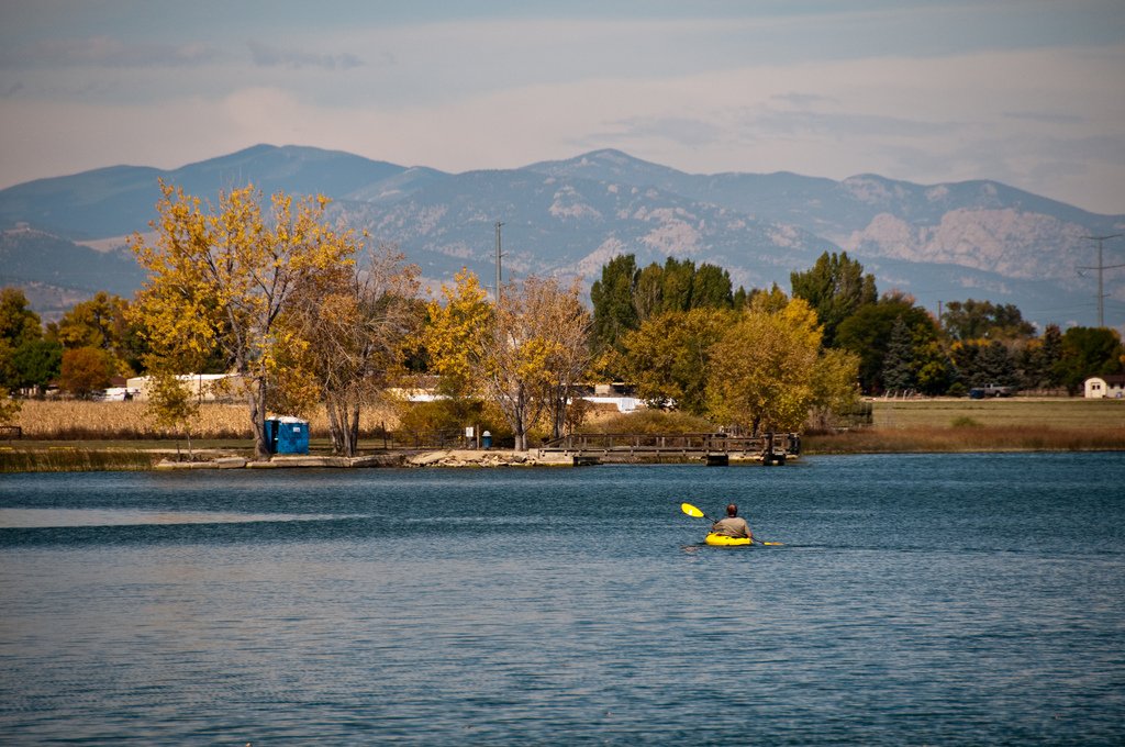 A kayaker on a reservoir with the mountains in the background