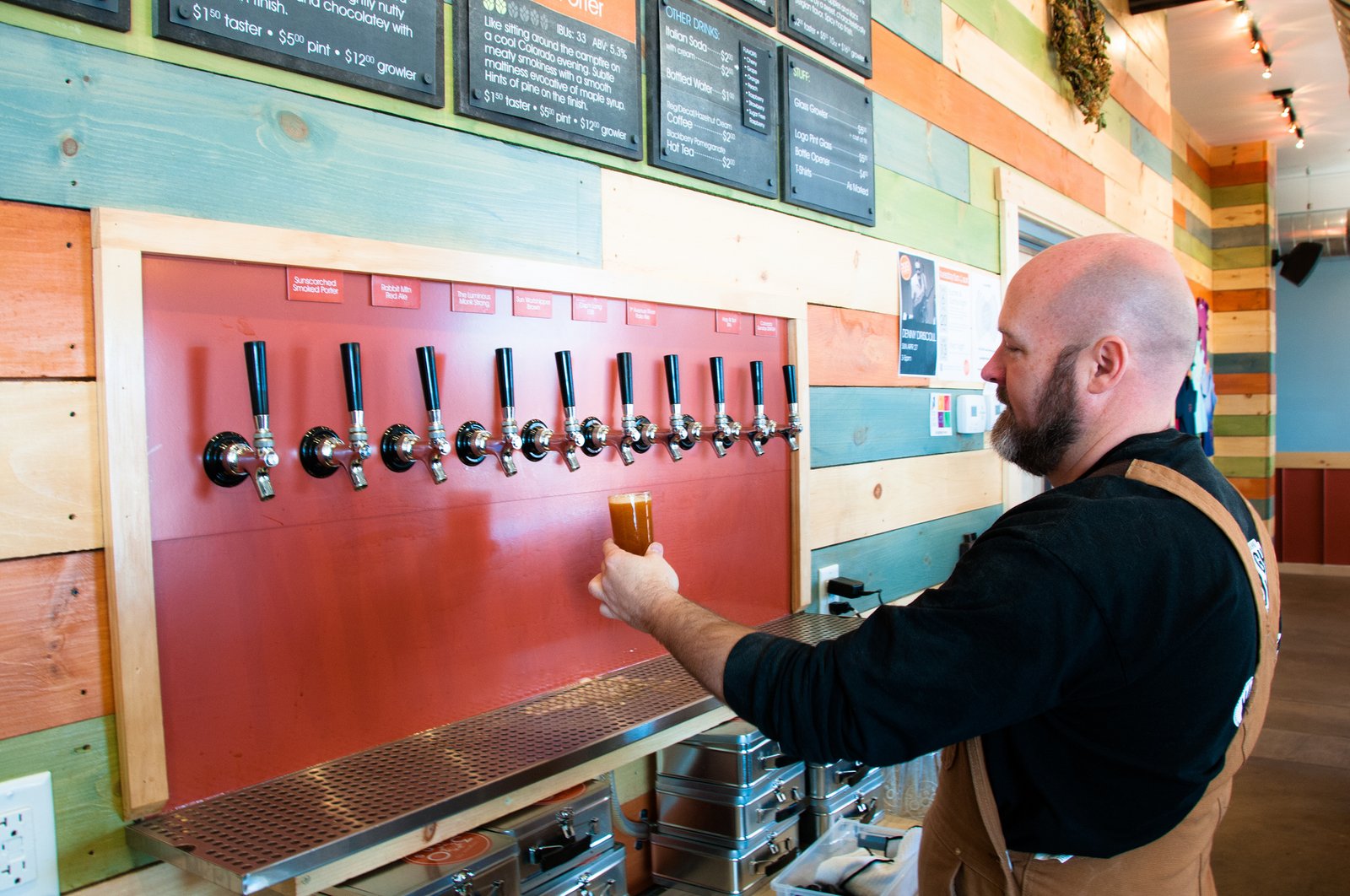 A man filling up beer from a row of taps