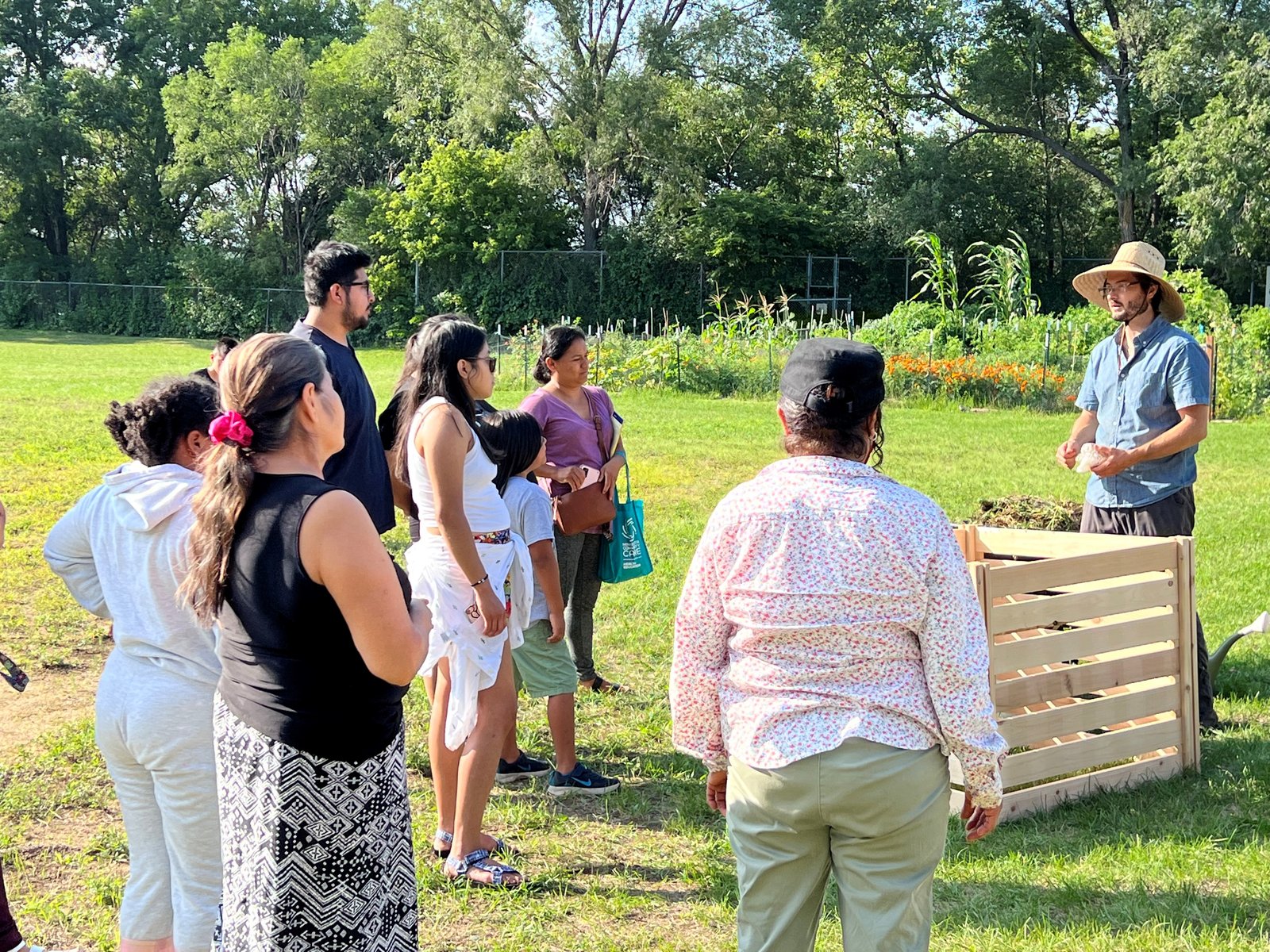 Image of a group of people learning to compost while outside