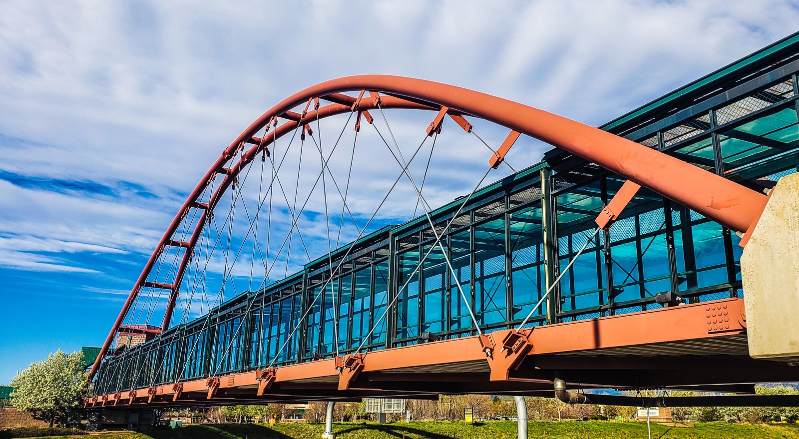 Large red arched bridge with a glass walkway.