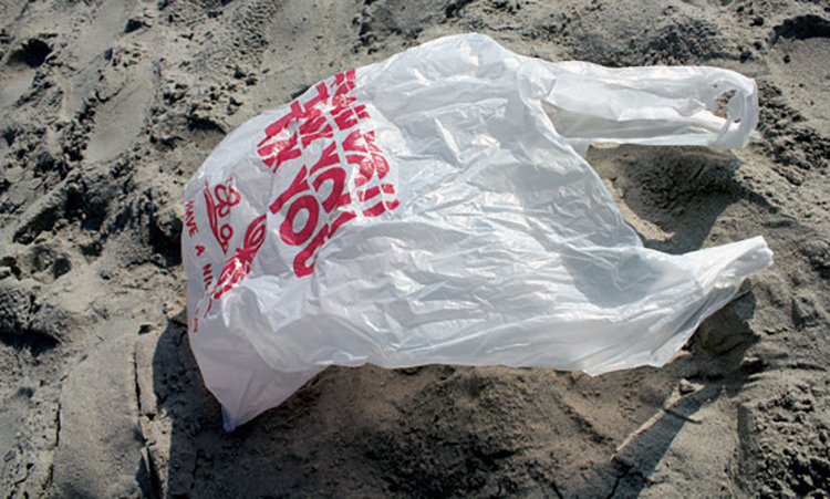 Single use plastic bag on sand